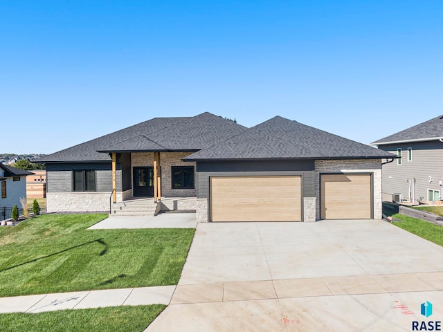 prairie-style home with a front yard and a garage