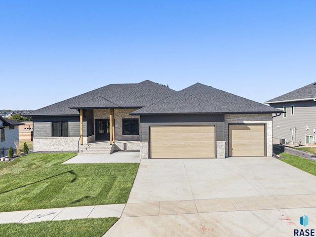 313 Red Spruce Ave, Sioux Falls, SD 57110 - prairie-style home with a shingled roof, a front lawn, stone siding, and an attached garage