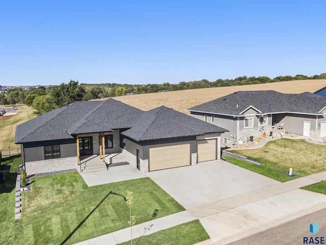 313 Red Spruce Ave, Sioux Falls, SD 57110 - view of front of home featuring a front yard, an attached garage, stone siding, driveway, and roof with shingles