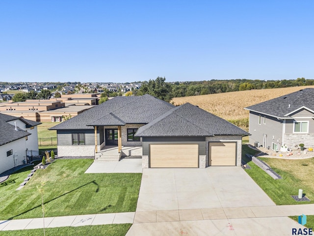 313 Red Spruce Ave, Sioux Falls, SD 57110 - prairie-style home with fence, a front lawn, an attached garage, a shingled roof, and concrete driveway