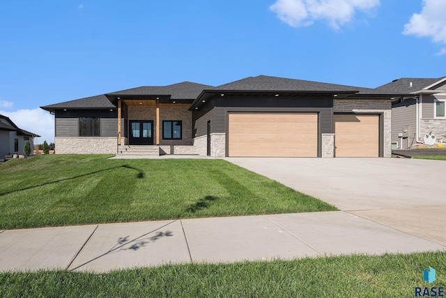 313 Red Spruce Ave, Sioux Falls, SD 57110 - prairie-style house featuring a garage, stone siding, driveway, and a front yard