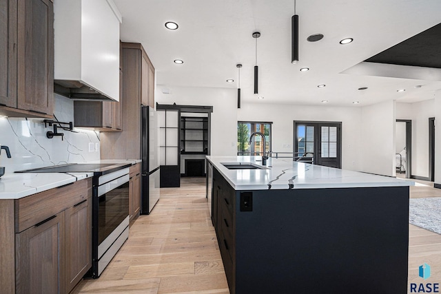 313 Red Spruce Ave, Sioux Falls, SD 57110 - kitchen featuring light wood-type flooring, electric range, freestanding refrigerator, a barn door, and a sink