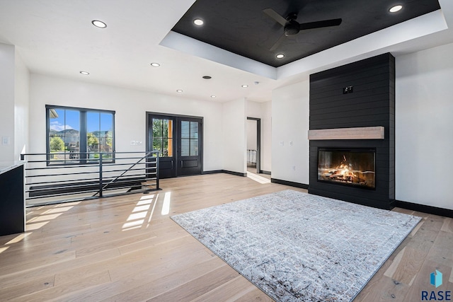 313 Red Spruce Ave, Sioux Falls, SD 57110 - living area with light wood-type flooring, baseboards, a fireplace, a ceiling fan, and a tray ceiling