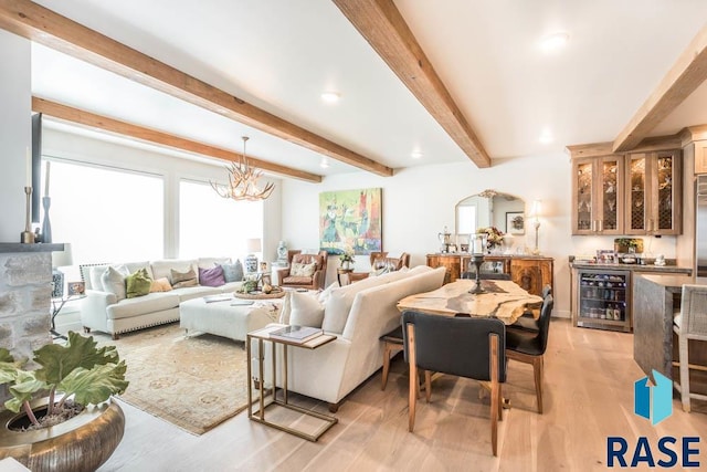 living room featuring an inviting chandelier, beverage cooler, beam ceiling, and light hardwood / wood-style floors