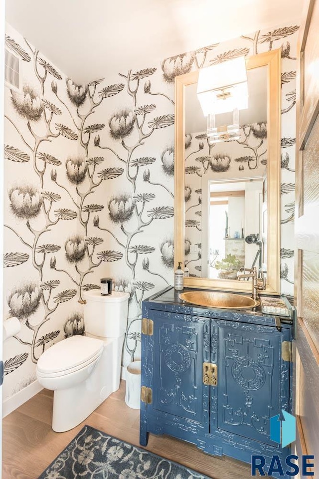 bathroom featuring vanity, hardwood / wood-style floors, and toilet