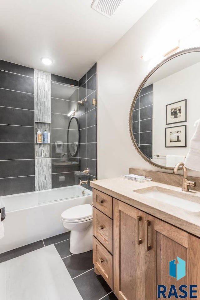 full bathroom with tiled shower / bath, vanity, tile patterned flooring, and toilet