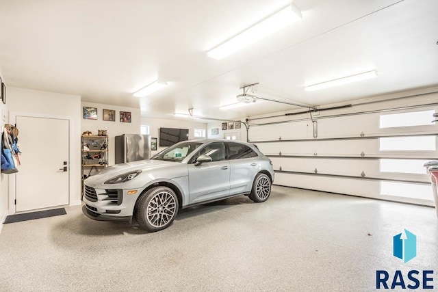 garage featuring stainless steel refrigerator and a garage door opener