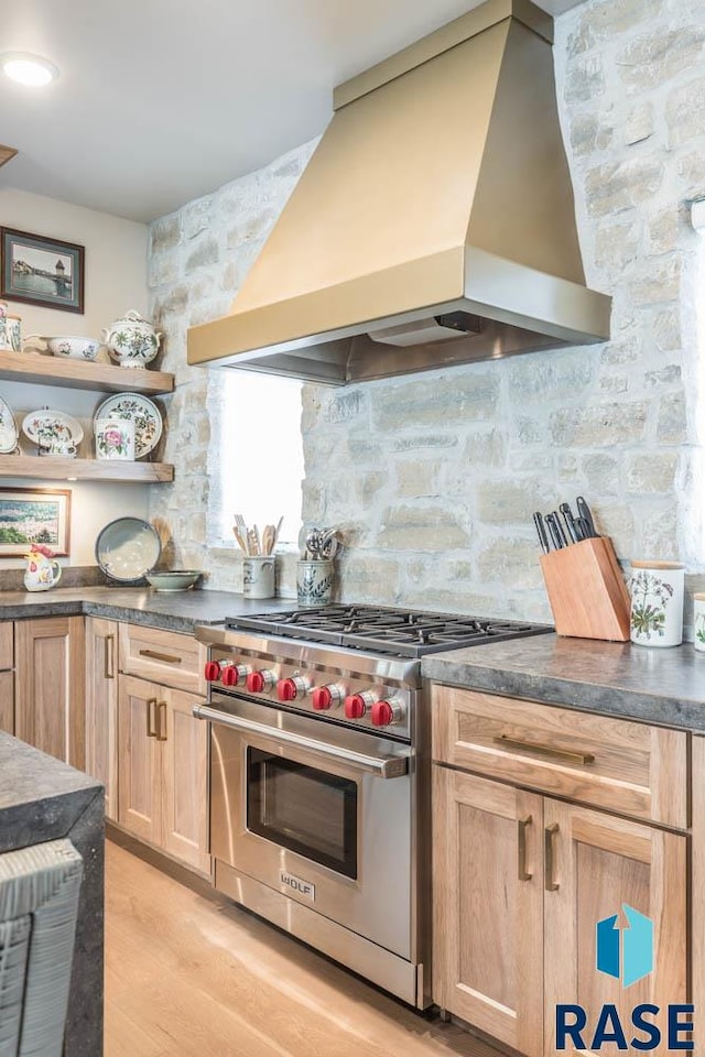 kitchen with custom range hood, light wood-type flooring, and luxury stove