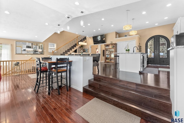 kitchen with pendant lighting, a breakfast bar area, a large island with sink, and white cabinetry