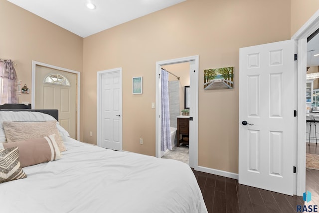 bedroom featuring ensuite bathroom and dark wood-type flooring