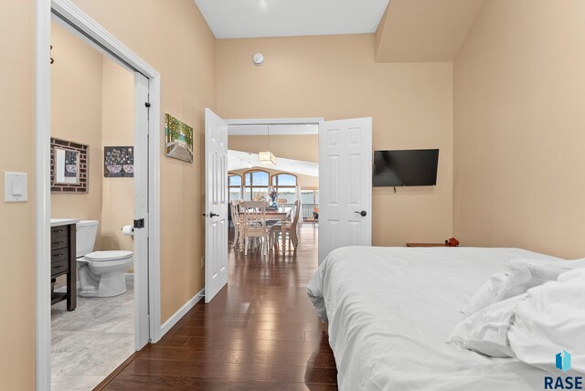 bedroom featuring connected bathroom, dark hardwood / wood-style floors, and a closet