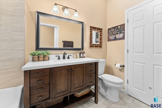 bathroom with vanity, toilet, a tub, and tile patterned floors