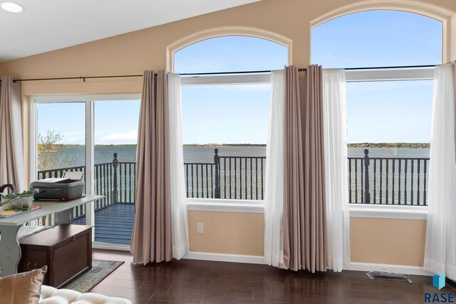 doorway featuring vaulted ceiling, dark hardwood / wood-style flooring, and a water view