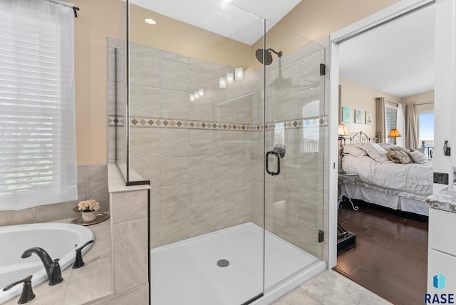 bathroom featuring shower with separate bathtub, hardwood / wood-style flooring, and plenty of natural light