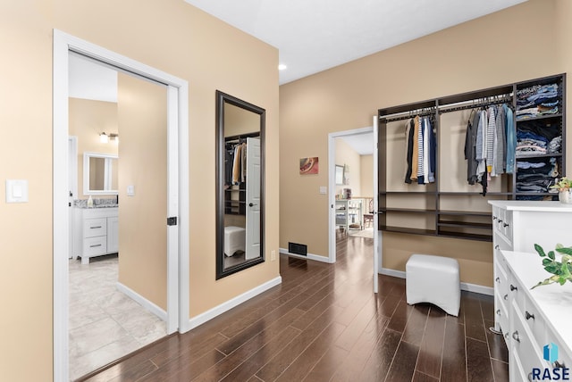 walk in closet with dark hardwood / wood-style flooring