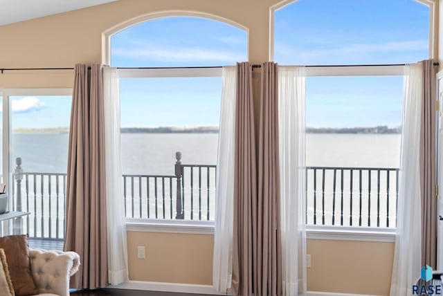 doorway with a water view and lofted ceiling