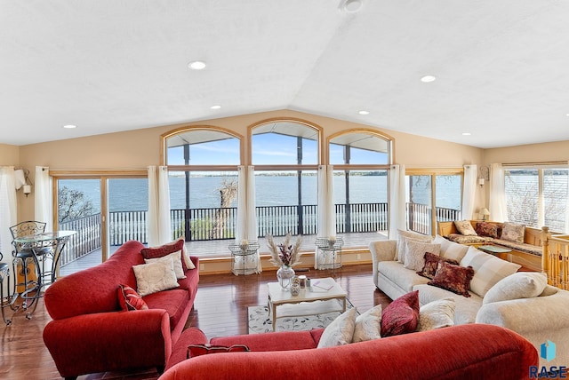 living room featuring lofted ceiling, a water view, and hardwood / wood-style floors