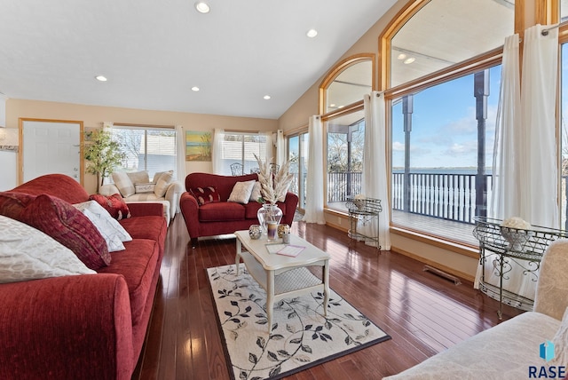 living room with a water view, lofted ceiling, and dark hardwood / wood-style floors