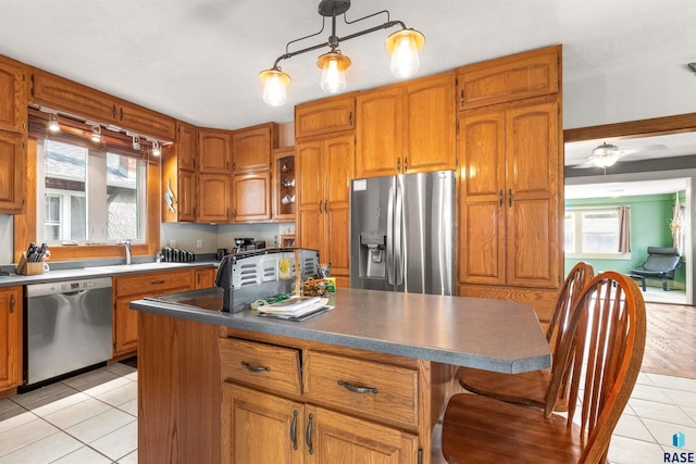 kitchen featuring pendant lighting, a center island, sink, light hardwood / wood-style flooring, and stainless steel appliances