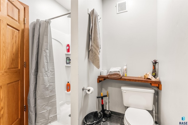 bathroom with toilet, curtained shower, and tile patterned flooring