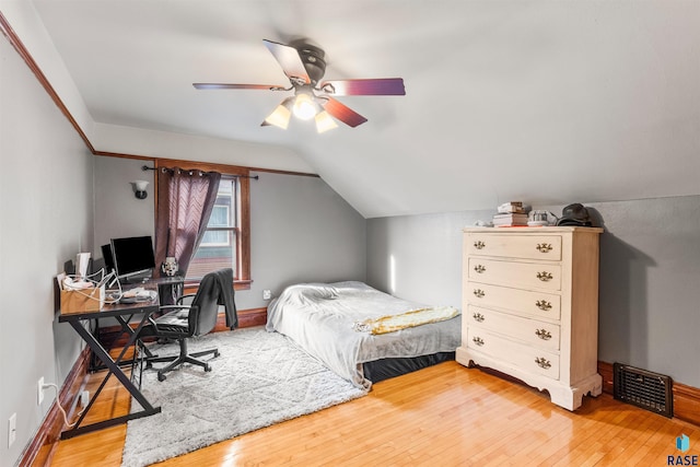 bedroom with ceiling fan, lofted ceiling, and hardwood / wood-style floors