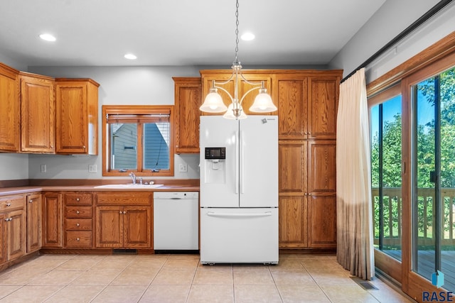 kitchen with white appliances, brown cabinets, and a sink