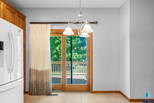 doorway to outside with baseboards, light tile patterned flooring, and a notable chandelier