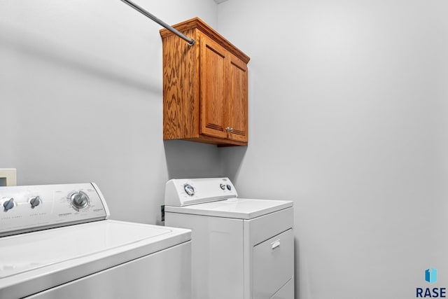 washroom featuring washing machine and dryer and cabinet space