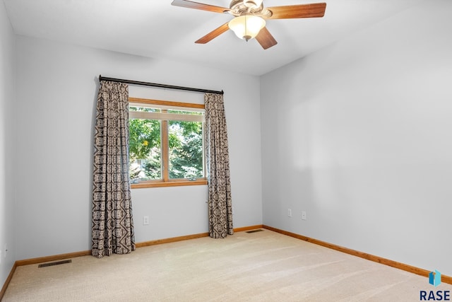 carpeted empty room featuring ceiling fan, visible vents, and baseboards