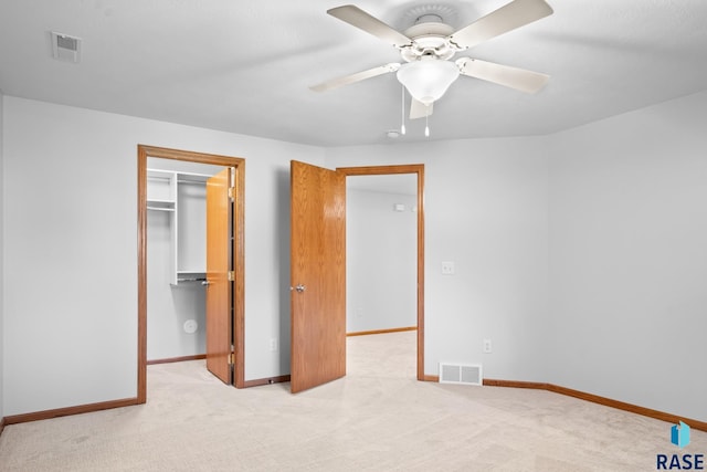 unfurnished bedroom featuring carpet, visible vents, a spacious closet, and baseboards