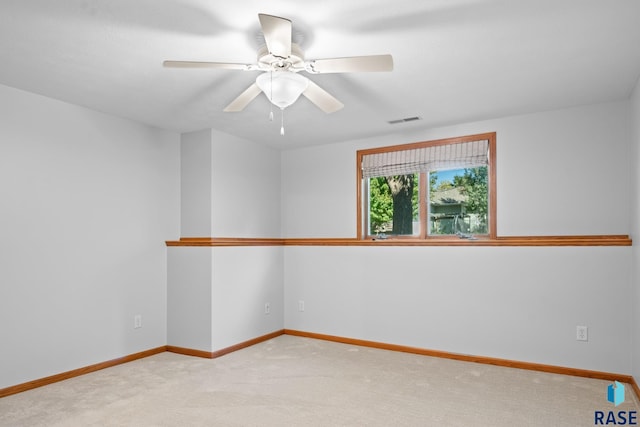 carpeted empty room featuring visible vents, baseboards, and a ceiling fan