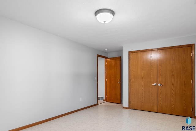 unfurnished bedroom featuring light floors, visible vents, baseboards, and a closet