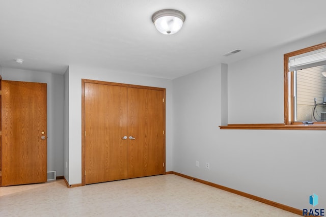 unfurnished bedroom with baseboards, a closet, visible vents, and tile patterned floors