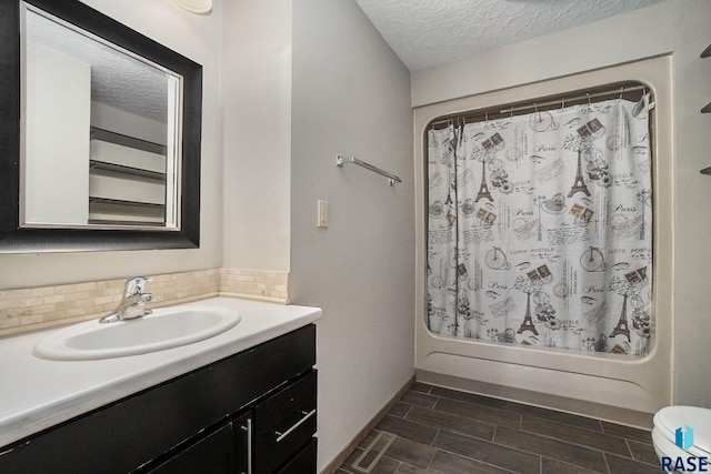 1512 W 7th St, Sioux Falls, SD 57104 - bathroom featuring backsplash, shower / bath combo with shower curtain, vanity, and a textured ceiling