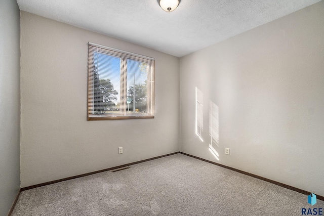 1512 W 7th St, Sioux Falls, SD 57104 - carpeted empty room with visible vents, a textured ceiling, and baseboards