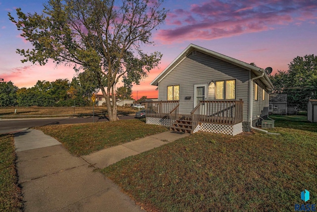 view of front of property with a wooden deck and a yard