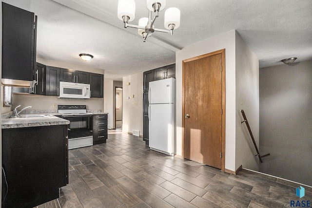 1512 W 7th St, Sioux Falls, SD 57104 - kitchen featuring white appliances, dark cabinets, light countertops, a sink, and wood tiled floor