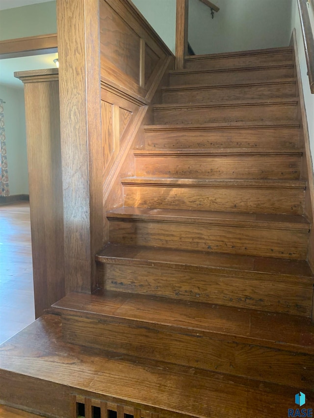 staircase with hardwood / wood-style floors