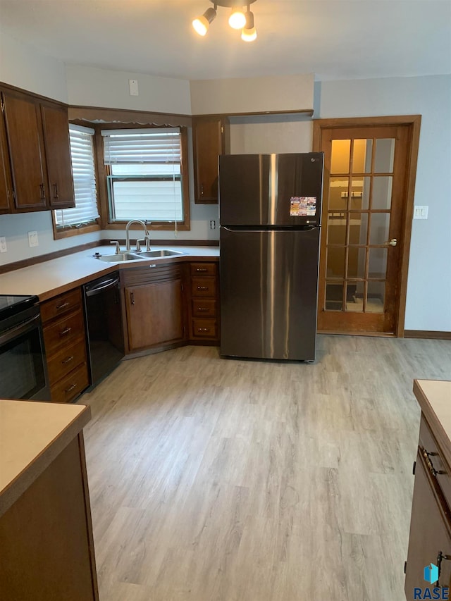 kitchen featuring light hardwood / wood-style flooring, sink, and black appliances