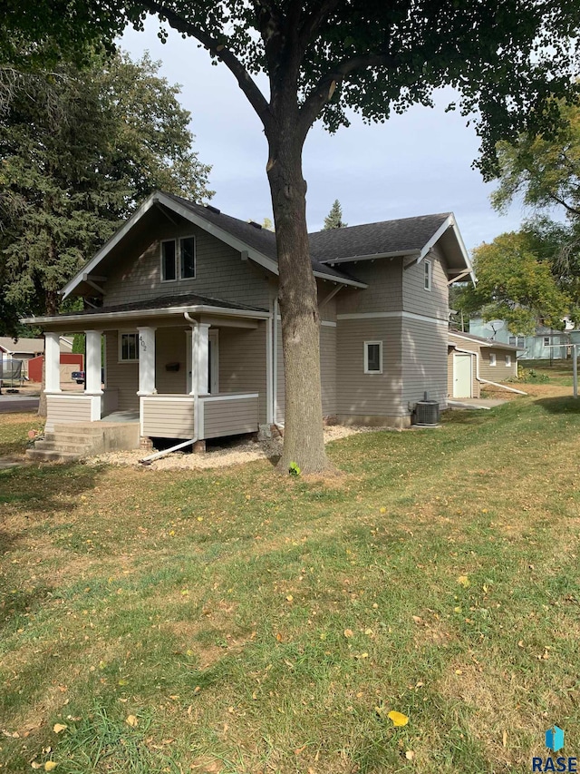 rear view of property with central AC and a yard