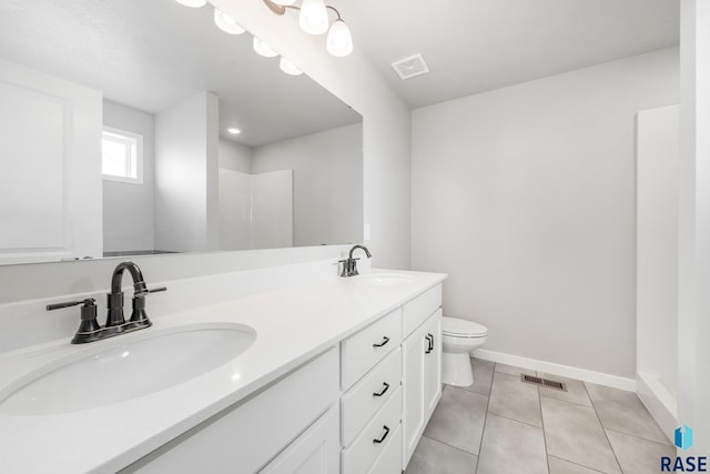 bathroom with tile patterned flooring, vanity, and toilet