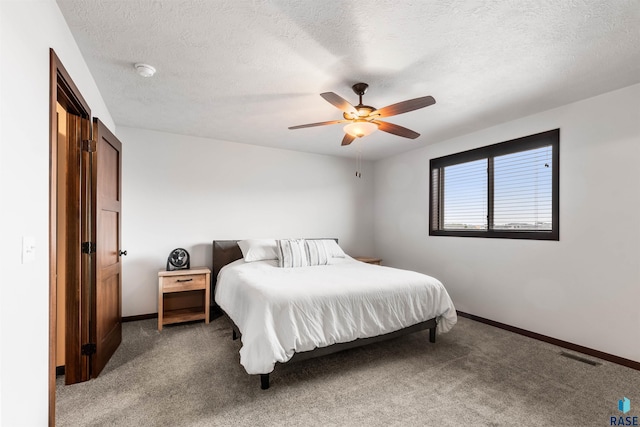 carpeted bedroom with a textured ceiling and ceiling fan