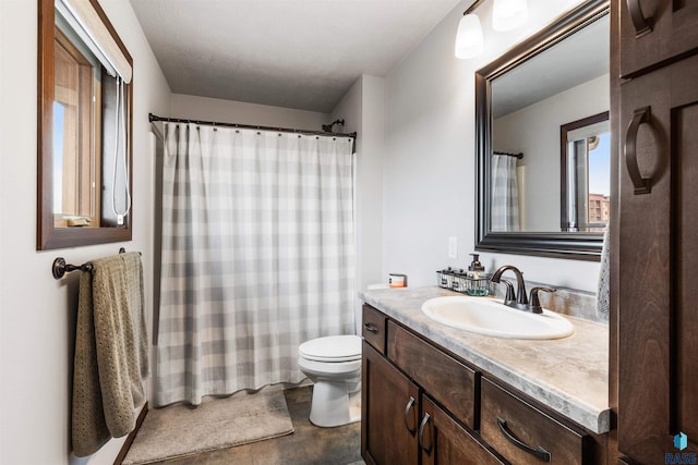 bathroom featuring toilet, walk in shower, and vanity