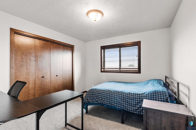 bedroom with a closet, carpet flooring, and a textured ceiling