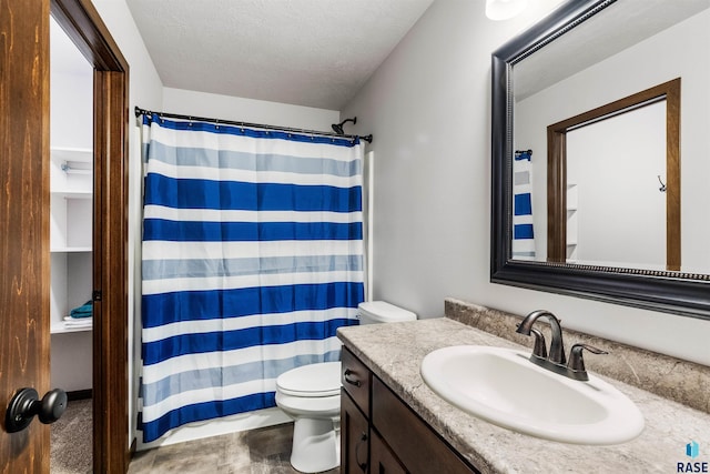 bathroom with vanity, toilet, a textured ceiling, and curtained shower