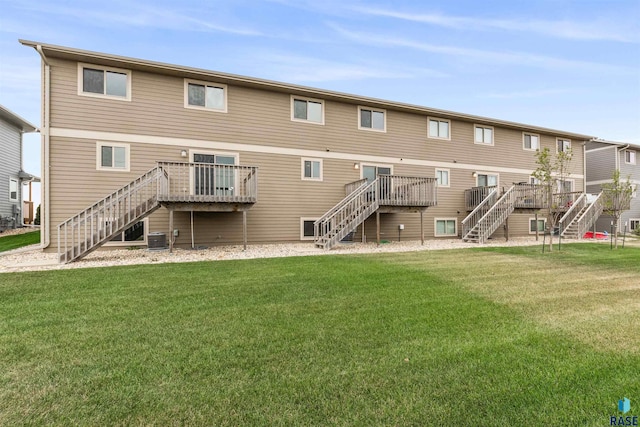 back of house featuring a wooden deck, central AC unit, and a lawn