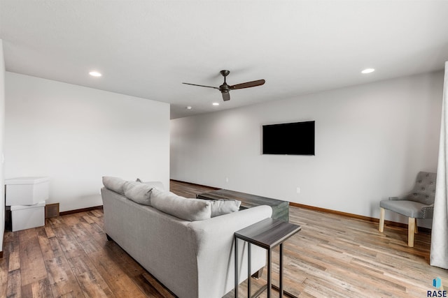 living room featuring ceiling fan and light hardwood / wood-style floors