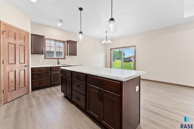 kitchen with a notable chandelier, decorative light fixtures, plenty of natural light, and a kitchen island