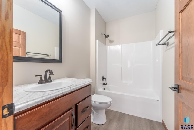 full bathroom featuring wood-type flooring, vanity, shower / tub combination, and toilet