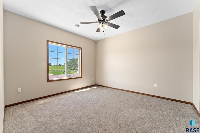 carpeted spare room featuring ceiling fan